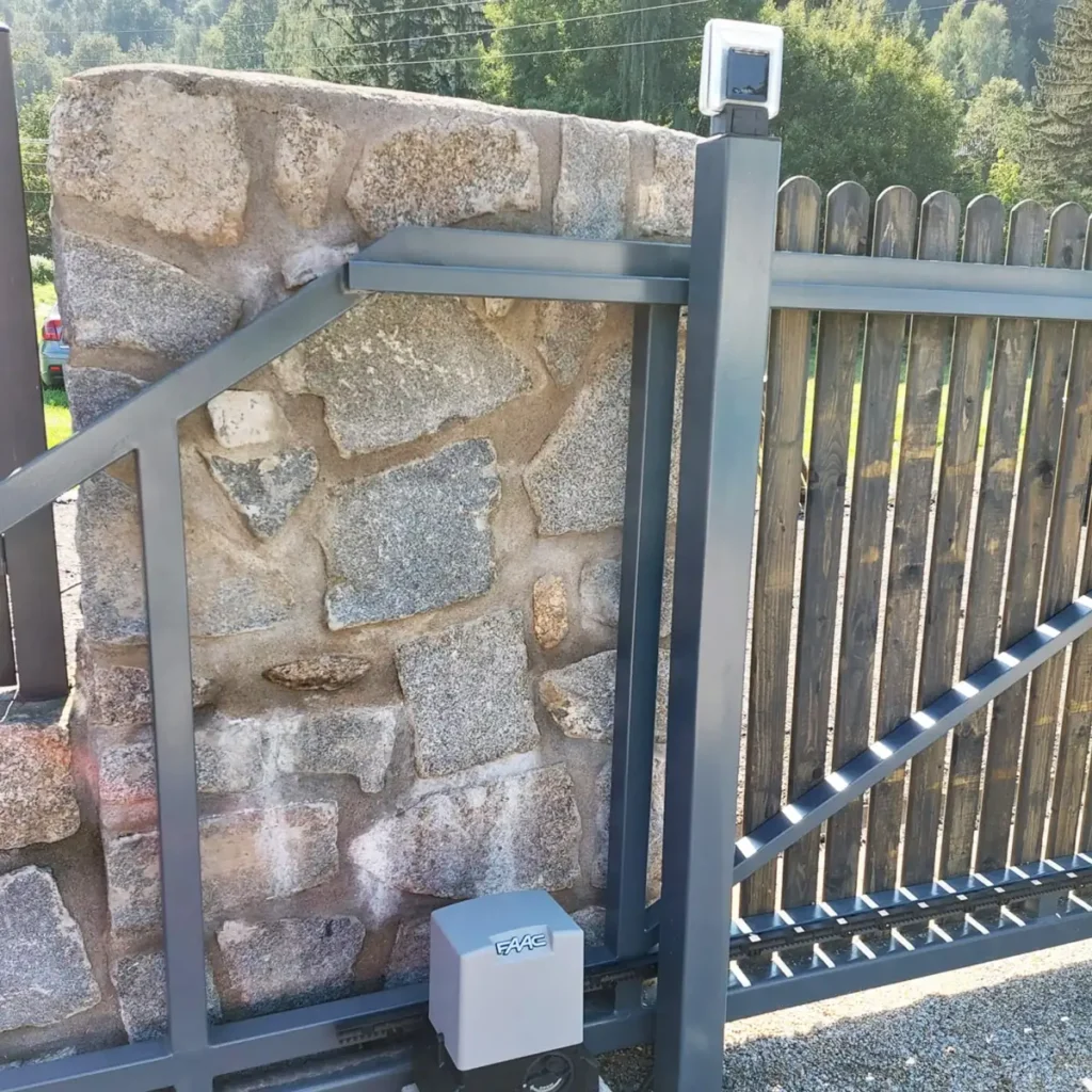 Elektryczna brama stalowa, przesuwna wkomponowana w kamienne ogrodzenie na posesji w Karpaczu.