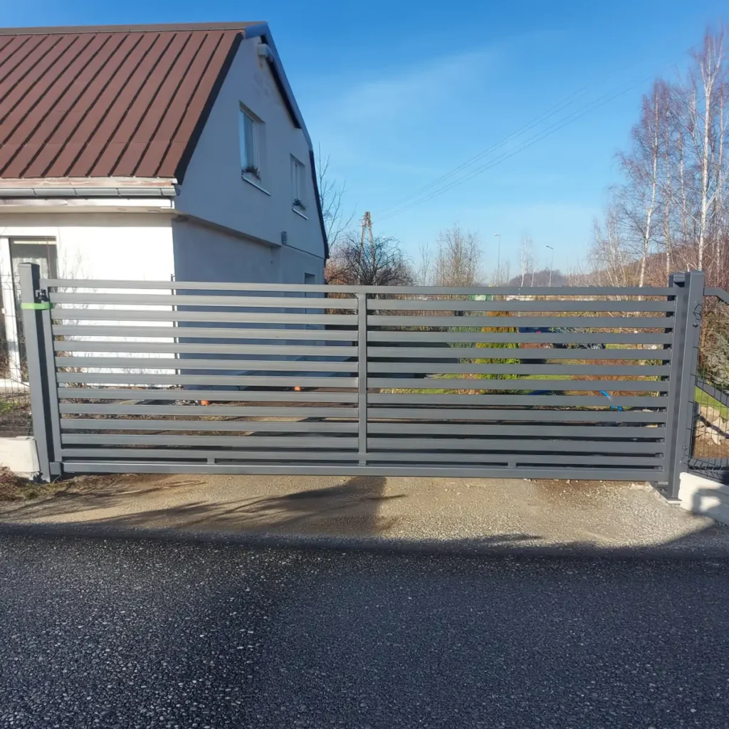 Przesuwana brama metalowa na wjeździe na podwórze domu jednorodzinnego niedaleko Zgorzelca 