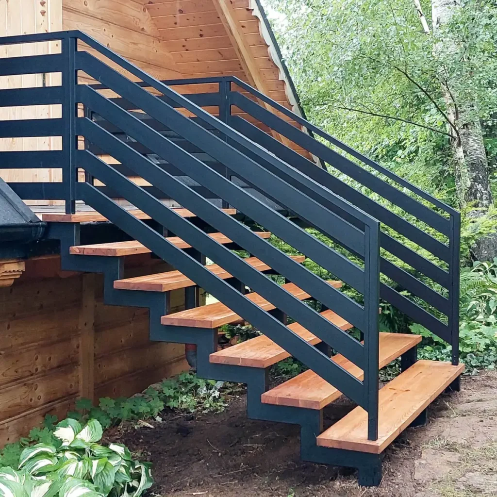 Schody zewnętrzne metalowe z drewnianymi stopniami i stalowymi poręczami.